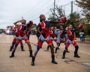 majorette dancers perform in the street during a parade