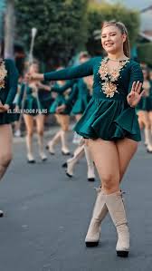 eastern european majorette dancers wearing green velvet costumes and boots walking in a parade